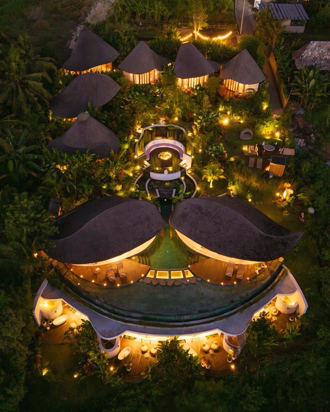 The retreat villas in Ubud from above, lit up among the trees at night
